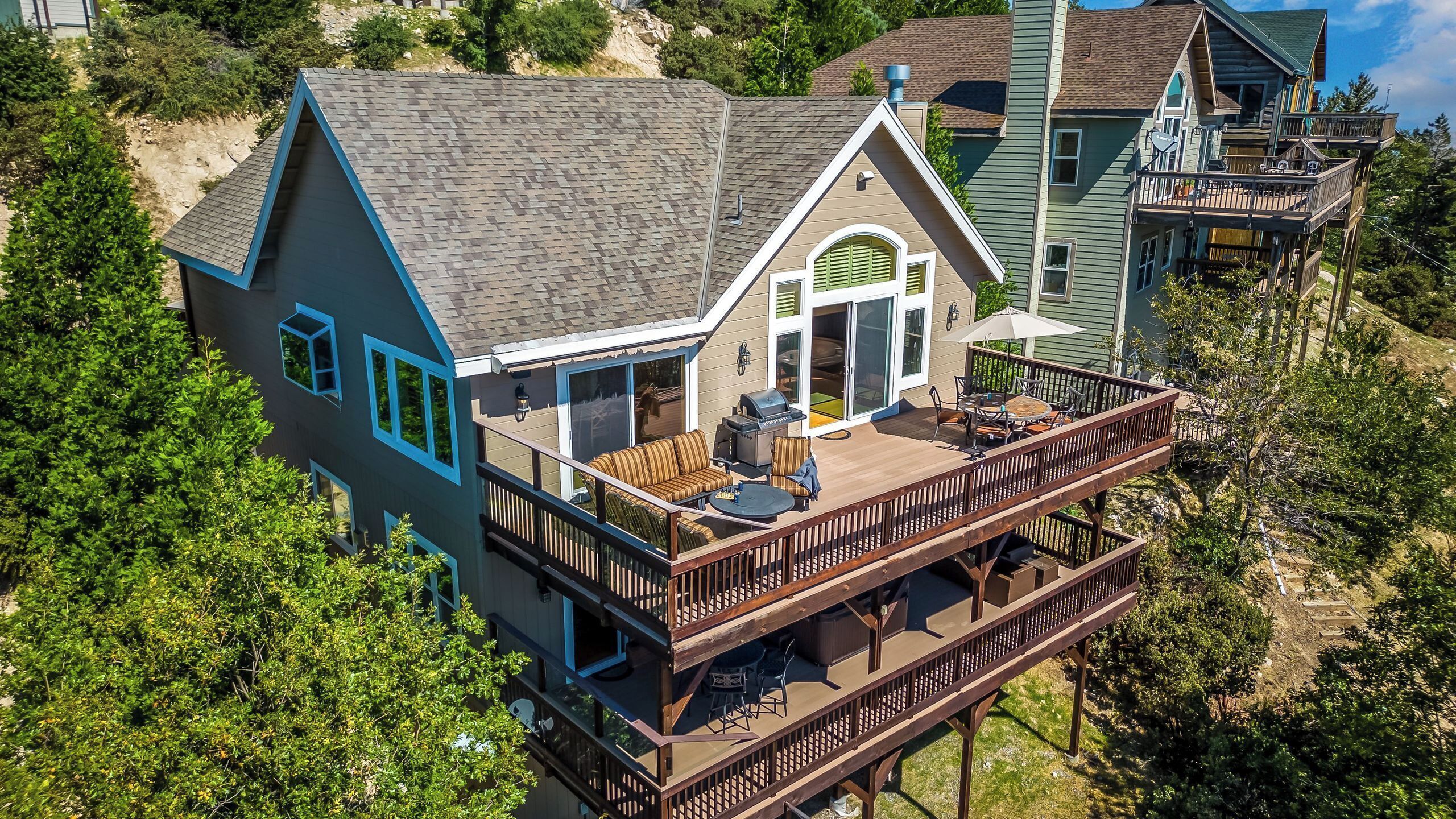 A two-story house with a deck, a covered patio, and a large window.