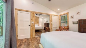 Une chambre à coucher avec un lit, une armoire en bois, une chaise et un miroir.