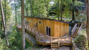A wooden cabin with a deck and stairs, surrounded by trees. - Artists Palette by Avantstay Colorful Retreat (Fairview)