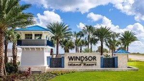 A resort sign with 'Windsor Island Resort' written on it, surrounded by palm trees and a clear sky. - Luxury 8BR Retreat | Private Pool, Spa & Resort Amenities | Near Disney (Davenport)