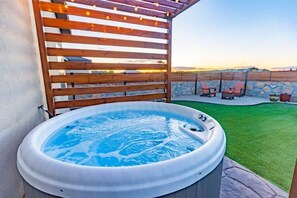A hot tub in a backyard with a wooden pergola overhead and a stone wall in the background. - Modern Farmhouse Near Bike Path with Spectacular Views! (Las Cruces)