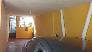 A car parked in a garage with yellow walls and a tiled floor.