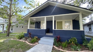 A single-story house with a porch, a front door, and a small front yard with plants and a pathway. - Bella Breeze (Sanford)