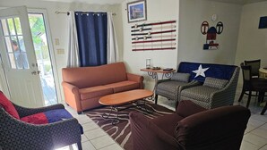 A living room with a sofa, armchair, and a coffee table. There is a patterned rug on the floor. - Texas themed cabin with a Shared fishing pier Not waterfront (Rio Hondo)
