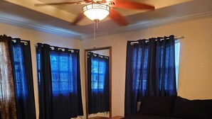 A bedroom with a bed, a ceiling fan, and curtains. - Texas themed cabin with a Shared fishing pier Not waterfront (Rio Hondo)