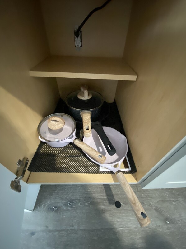A kitchen with a stove, a pot, a pan, and a spatula. - The Cherry Blossom (Sanford)