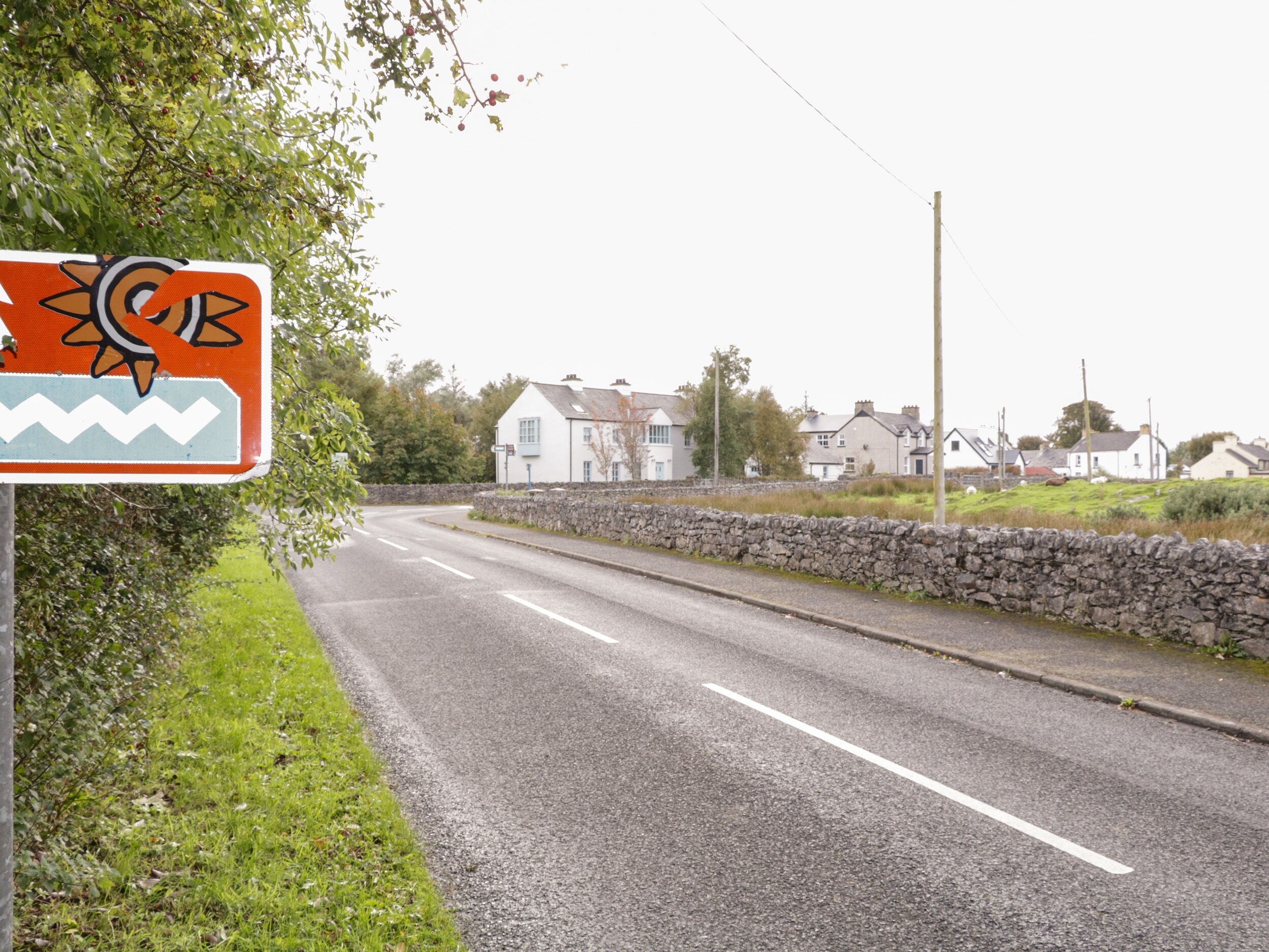 A road with a sign indicating a roundabout ahead.