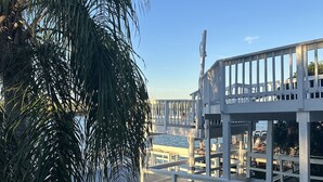 A wooden deck with a railing, overlooking a body of water. - EMMA’S COTTAGE; WATERFRONT FISHING PIER (Rio Hondo)