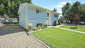 A two-story house with a front yard, a gravel driveway, and a small garden area. - Home in Kanab with Game Room. Sleeps 10, Pets OK! (Kanab)