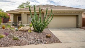 A house with a garage, surrounded by a garden with various cacti and rocks. - Snowbirds Welcome! Anthem Gem w/ Fairway Views (Anthem)