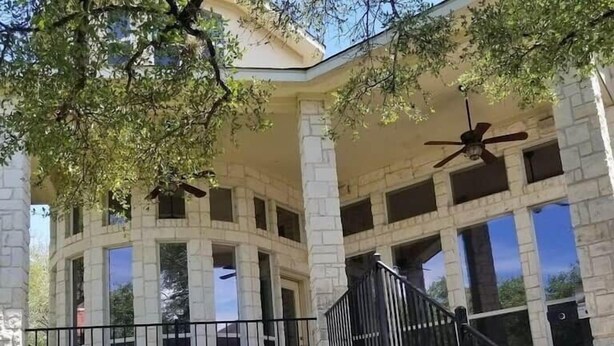 Un bâtiment à deux étages doté d’un patio couvert, d’un escalier et d’un ventilateur de plafond.