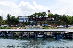 Ein Yachthafen mit vertäuten Booten, ein Gebäude mit der Aufschrift 'Briarcliff Marina' und ein Leuchtturm im Hintergrund.