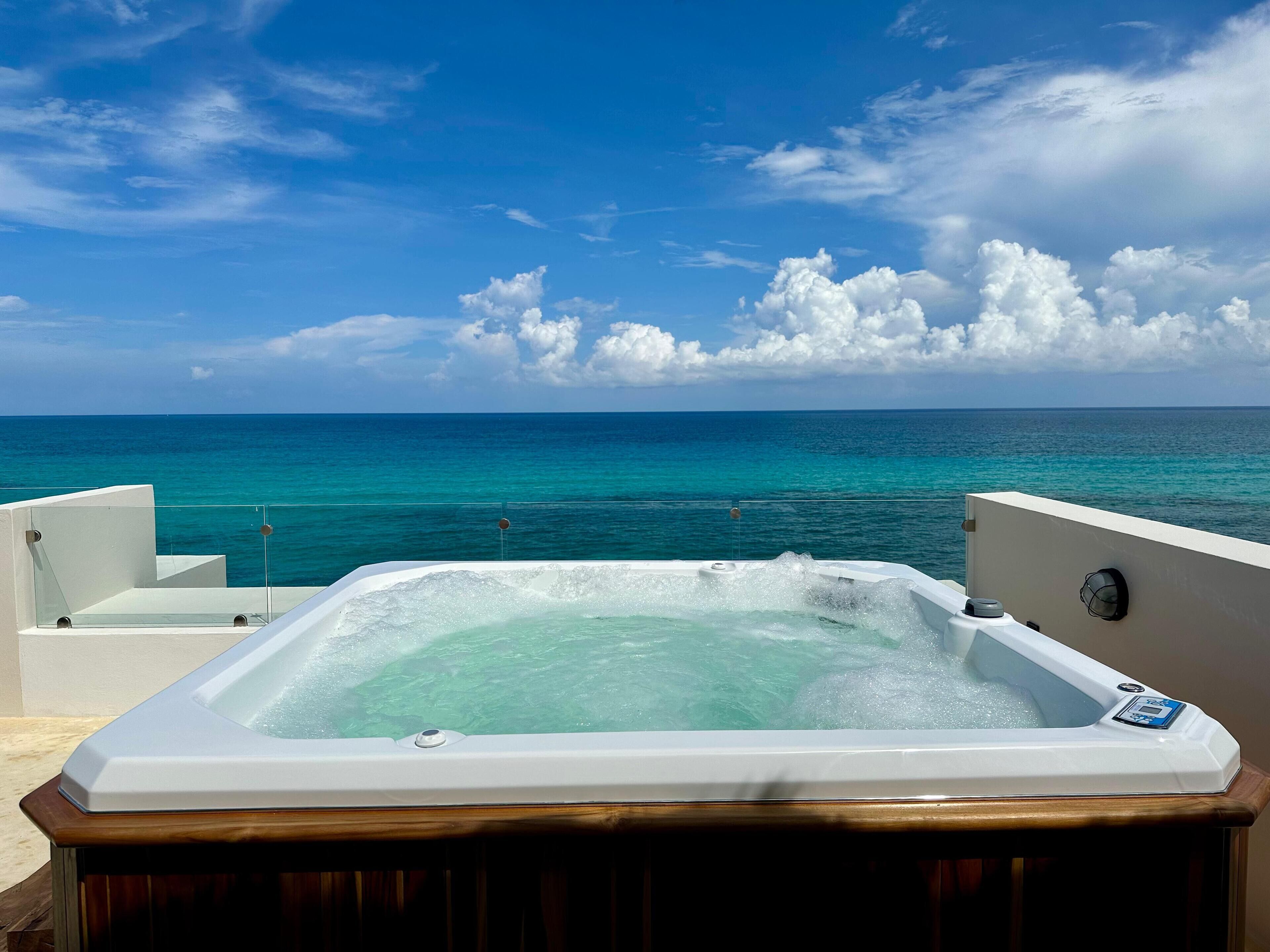 Un jacuzzi con vista al océano y un cielo despejado.