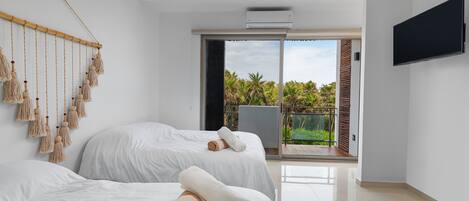 Une chambre d’hôtel moderne avec deux lits, une grande fenêtre et un téléviseur à écran plat.