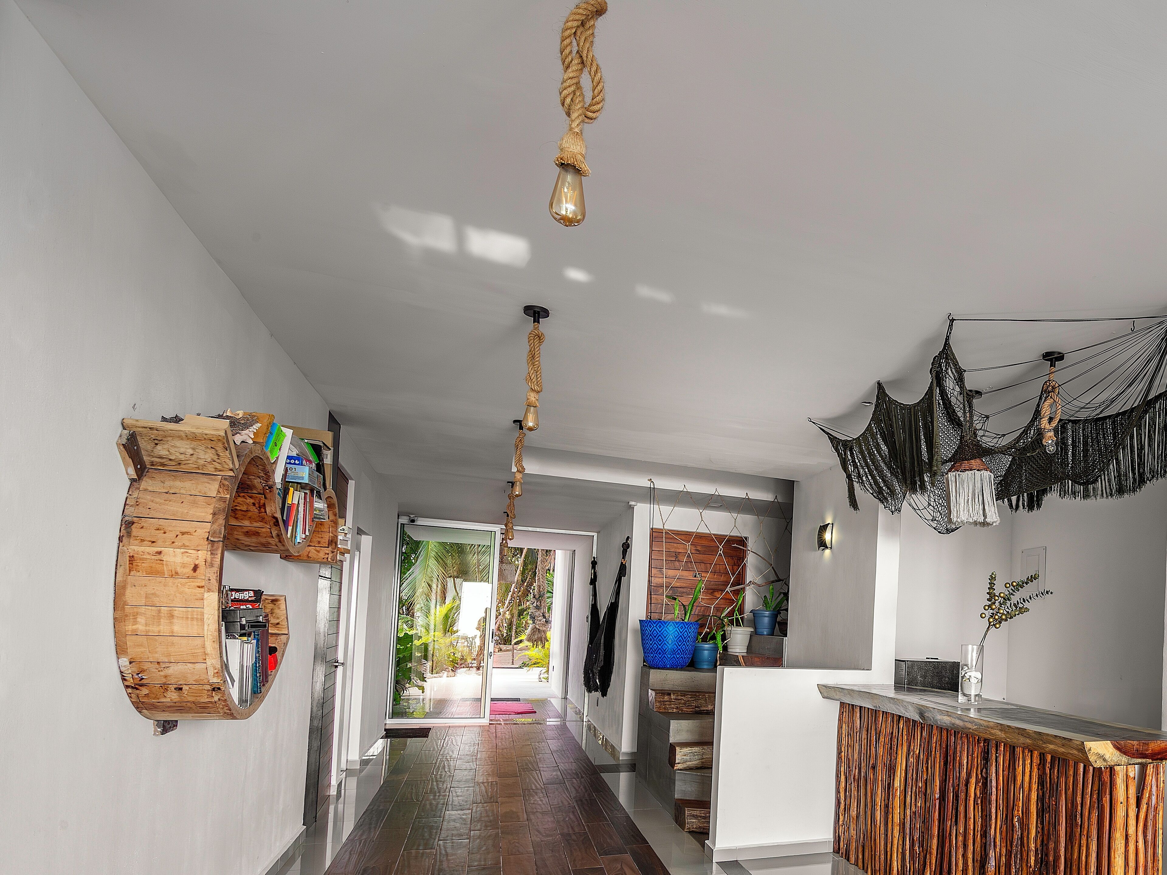 Una cocina moderna con una isla de madera, una lámpara colgante de cuerda y una hamaca.