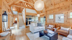 Un intérieur de cabane en bois spacieux, comprenant un espace de vie, une cuisine et un escalier.