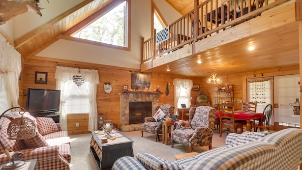 A cozy log cabin interior with a fireplace, wooden furniture, and a balcony. - Virginia Mountain Cabin w/ Decks & Fireplaces (Fulks Run)