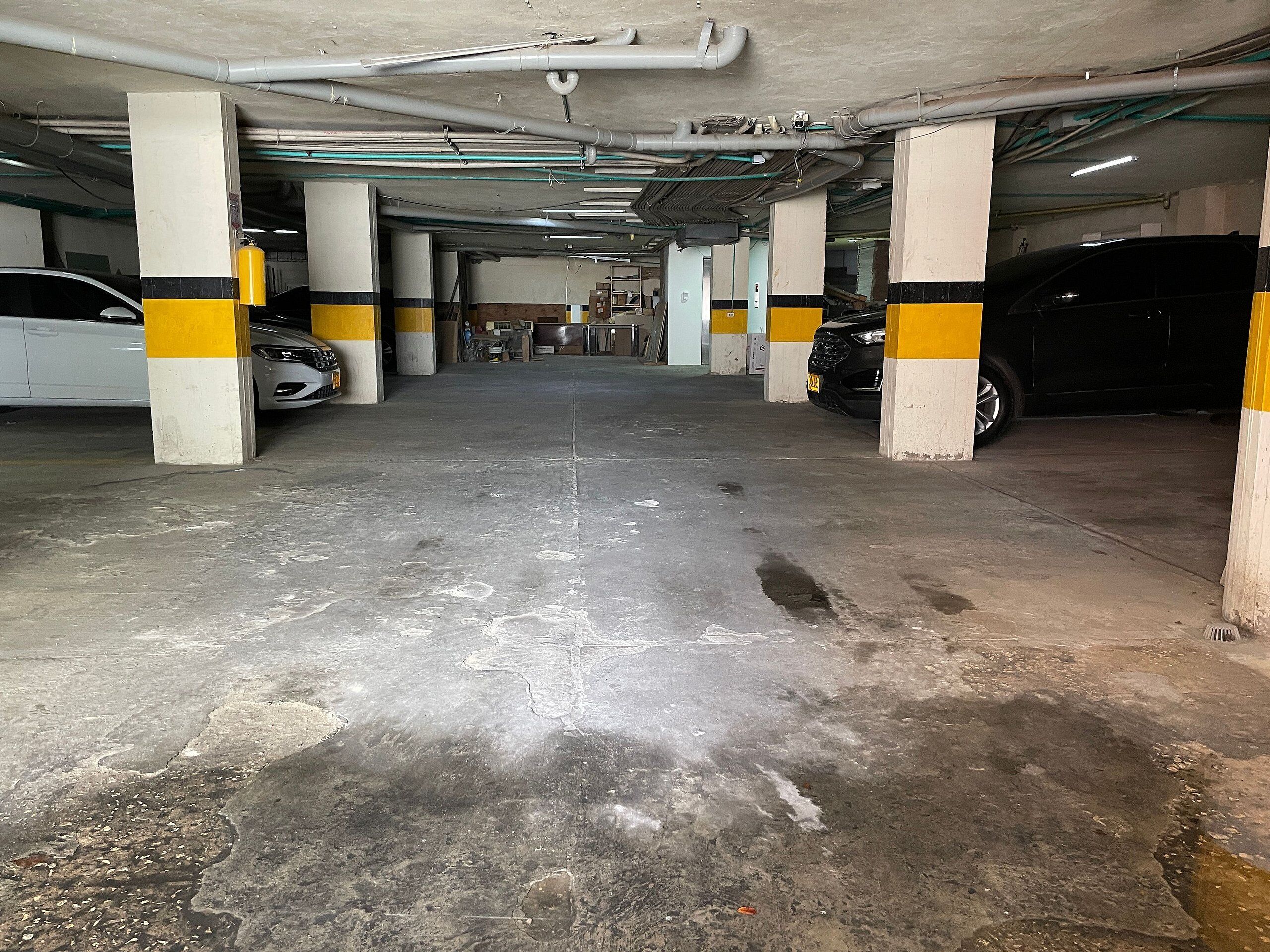 A multi-level parking garage with concrete floors and pillars painted in yellow and white.