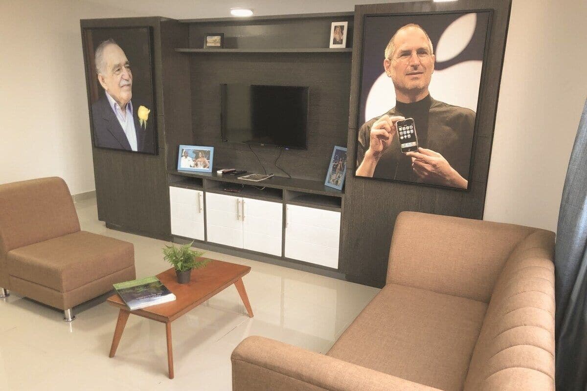 A modern waiting area with two sofas, a coffee table, and a flat-screen TV mounted on the wall.