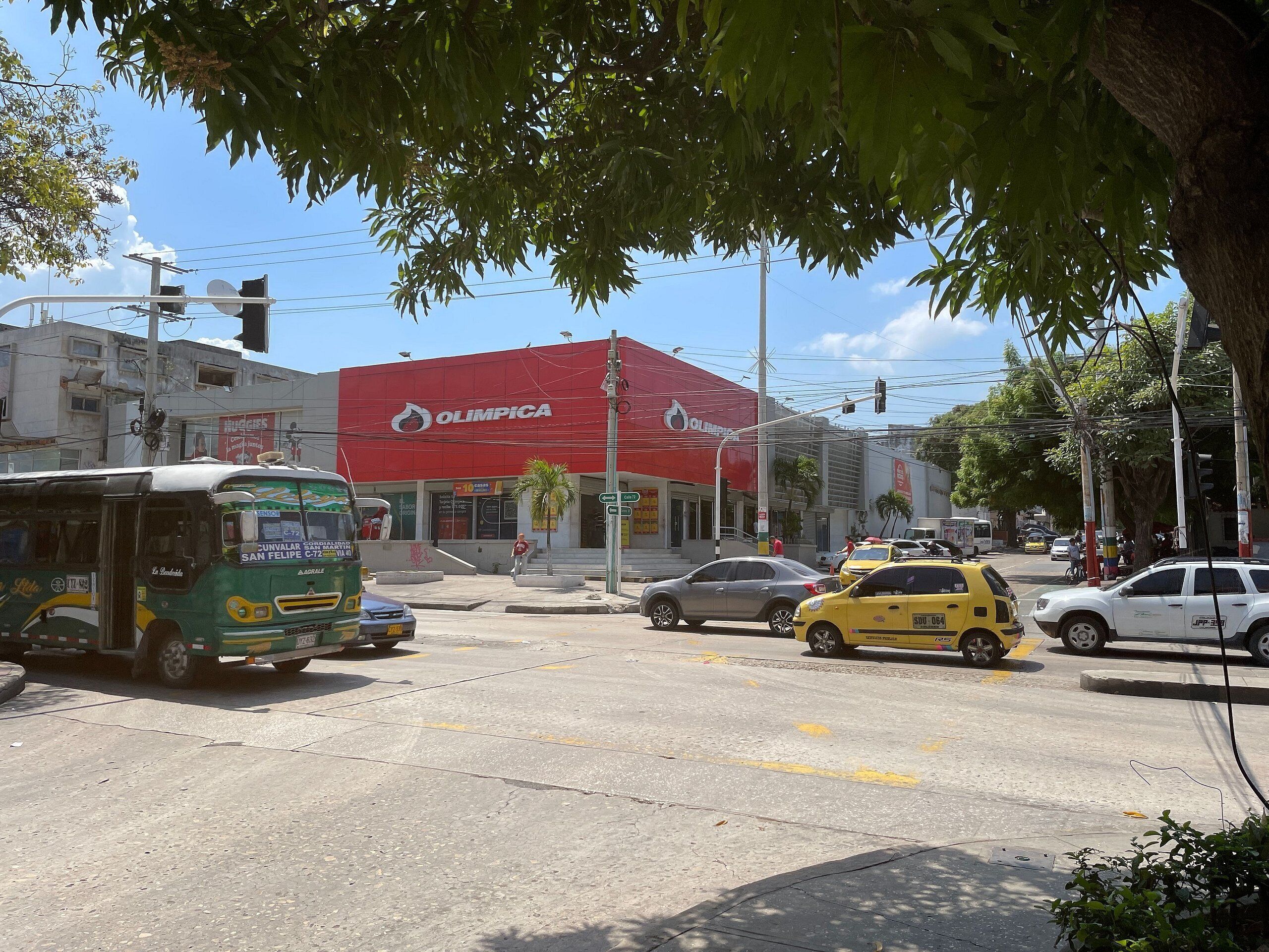 A street scene with a red building labeled 'OLIMPICA'.