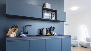 A modern kitchen with a built-in microwave, a kettle, and a knife block. - zzzpace Smart-Hotel Bielefeld (Bielefeld)