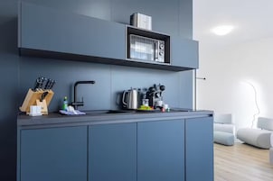 Una cocina moderna con microondas integrado, hervidor y bloque para cuchillos.