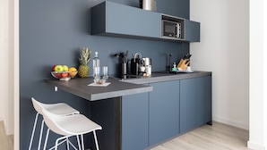 A modern kitchen with grey cabinets, a microwave, and a fruit bowl on the counter. - zzzpace Smart-Hotel Bielefeld (Bielefeld)