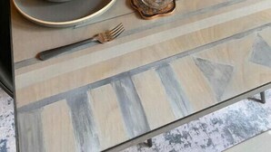 Uma mesa de jantar posta com tigelas, copos e talheres.
