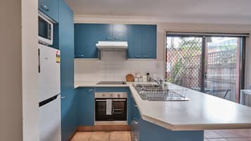 Apartamento, 1 quarto (Private Courtyard) | Cozinha privada | Geladeira grande, micro-ondas, fogão, cooktop