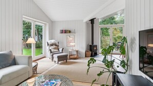 Een gezellige woonkamer met een bank, fauteuil en een open haard.
