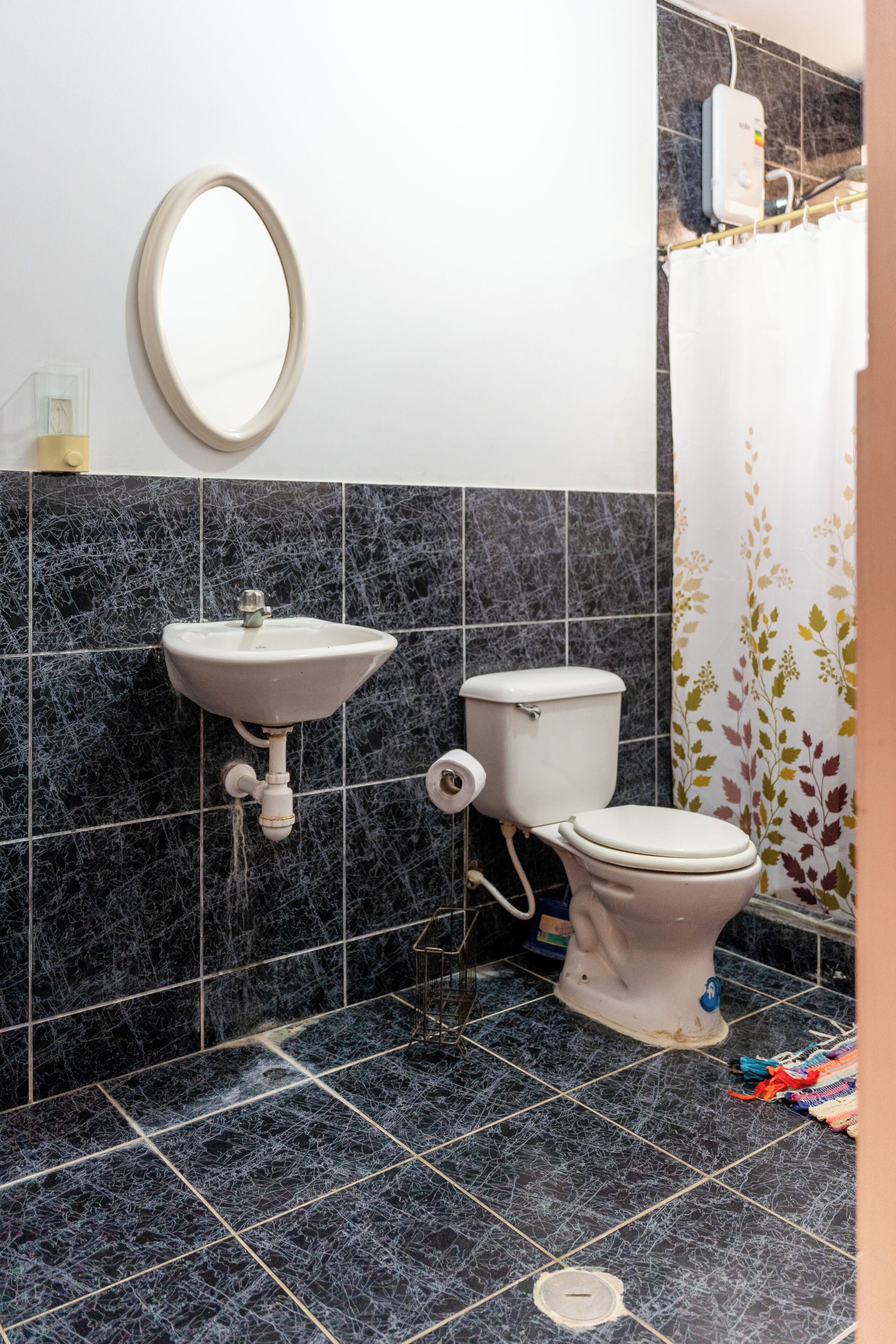 Un baño con lavamanos, inodoro y espejo.