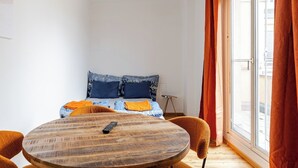 Une pièce comprenant un lit, une table ronde en bois et une chaise.