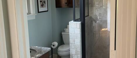 Chuveiro, toalhas de banho, sabonete, papel higiênico