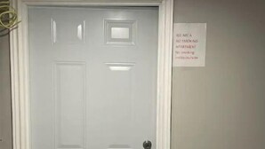 Une porte blanche avec une pancarte indiquant « Il est interdit de fumer dans cet appartement ».