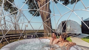 Un jacuzzi con una estructura metálica geométrica al fondo.