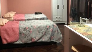 A room with two beds, a desk, and a wardrobe.
