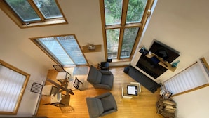 A spacious living room with a large window, a fireplace, and a cozy seating area.