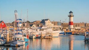 A marina with boats docked, a lighthouse, and buildings in the background. - Art Gallery Family Home - Southern California Style - Excellent Location (San Diego)