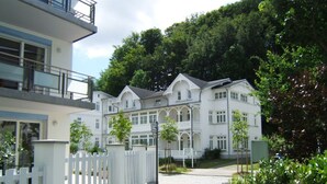 A large, white, multi-story building with a symmetrical facade, a gated entrance, and a paved pathway leading to it. - Villa Amanda - Strandnahe Fewo in Zentraler Aber Ruhiger Lage in Binz - Villa Amanda Fewo Nr.09 (Binz)