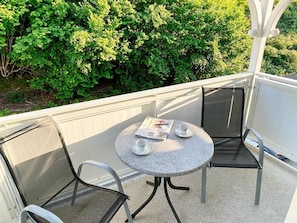 A small outdoor balcony with a round table and two chairs, a newspaper, and a cup. - Villa Amanda - Strandnahe Fewo in Zentraler Aber Ruhiger Lage in Binz - Villa Amanda Fewo Nr.09 (Binz)