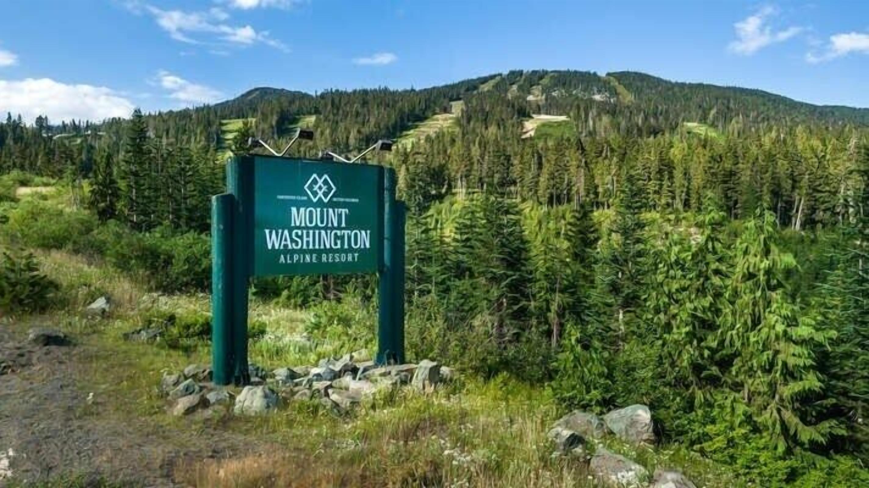 Cartell de Mount Washington Alpine Resort amb un paisatge de muntanyes al fons.