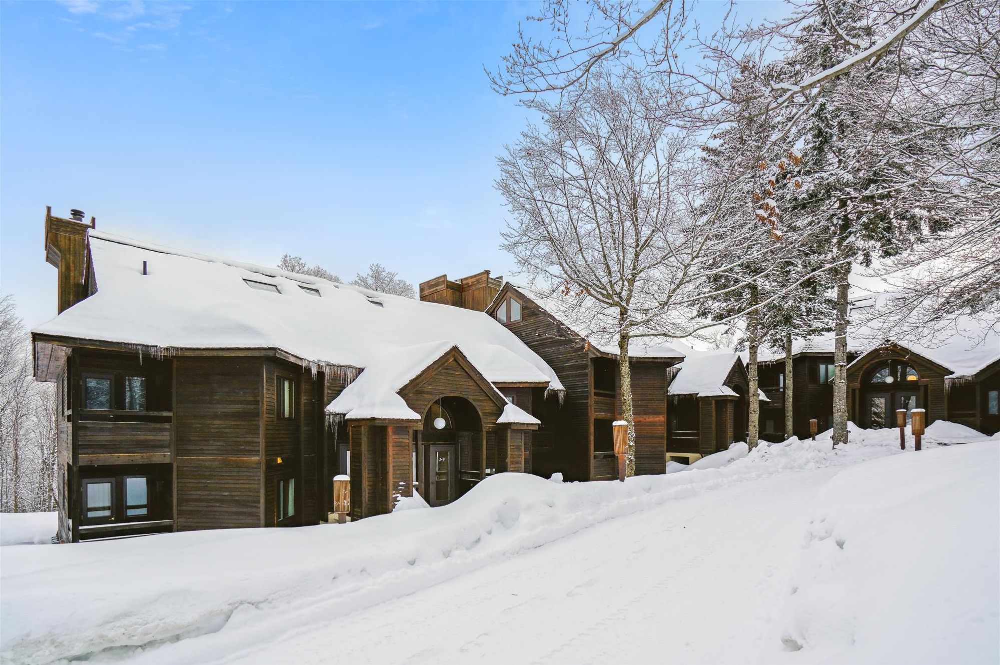 A True Vermont Winter Setting - Highridge sits beautifully among snow-covered trees and mountainside buildings during ski season.