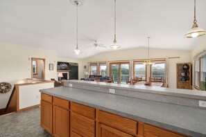 A spacious kitchen with a large island, wooden cabinets, and pendant lighting. - Sunshine Daydream - Oceanside, Private Pool, Hot Tub and Game Room (Corolla)