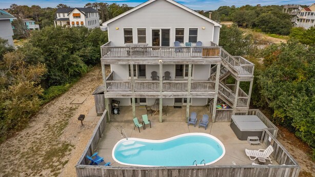 Ein zweistöckiges Haus mit Pool, Liegestühlen und Whirlpool.