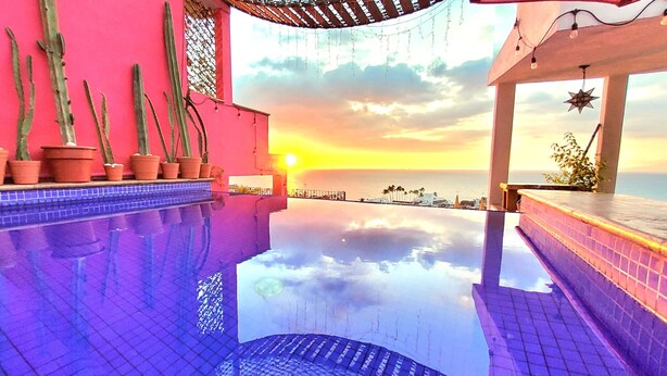 A pool with a sunset view, potted cacti, and a star decoration. - Tree-House Apt with Panoramic Ocean View+Pool+Steps to Beach & Malecon/Boardwalk (Puerto Vallarta)