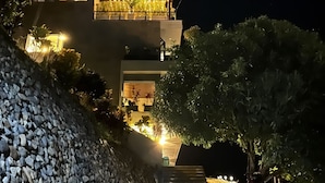 Um edifício moderno com um muro de pedra e um caminho de cascalho que leva à entrada.