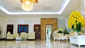 Eine geräumige Lobby mit einem Chandelier, bequemen Sitzgelegenheiten und einer großen Blumenkomposition.