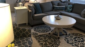 A living room with a sofa, a round coffee table, a lamp, and a ceiling fan. - Country setting. Two miles from downtown Petoskey.  (Petoskey)