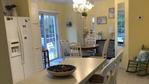 A kitchen with a long island, white chairs, and a chandelier. - Country setting. Two miles from downtown Petoskey.  (Petoskey)