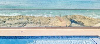 Stunning views of Seven Mile Beach, luxurious rooftop and oceanfront pool.